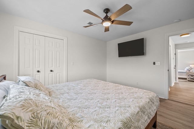 bedroom featuring ceiling fan, a closet, and light hardwood / wood-style flooring