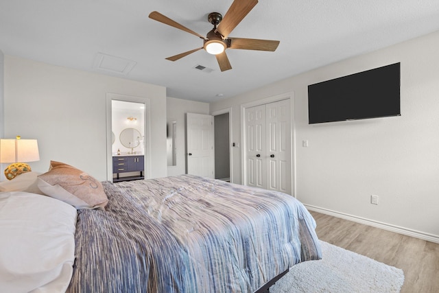 bedroom with hardwood / wood-style flooring, ceiling fan, ensuite bathroom, and a closet