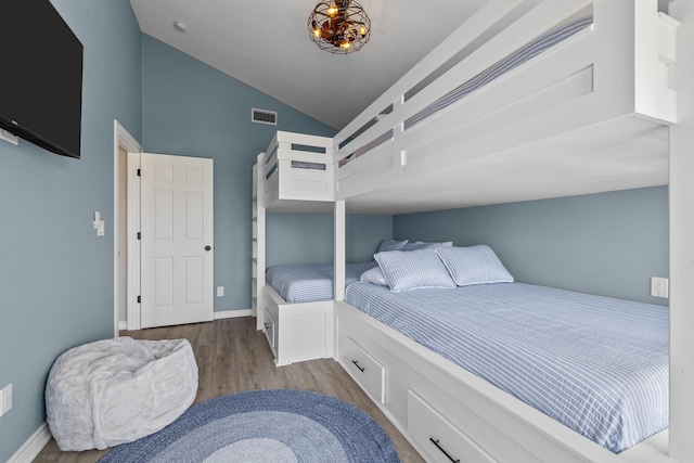 bedroom with light hardwood / wood-style flooring and lofted ceiling