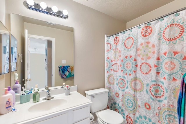 bathroom with vanity, a textured ceiling, toilet, and curtained shower