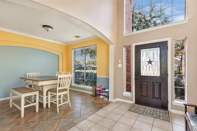 entryway featuring crown molding and light tile patterned floors