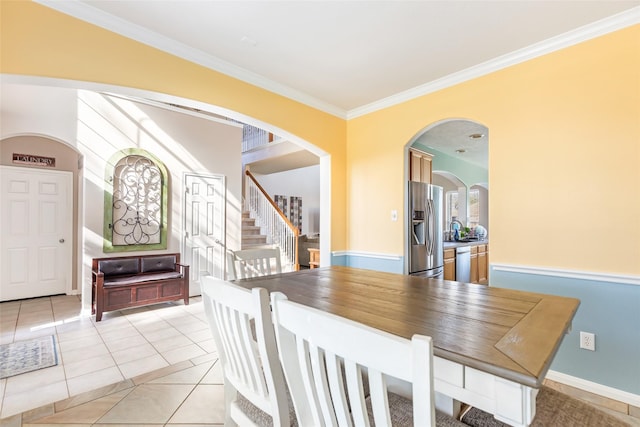 tiled dining room featuring ornamental molding