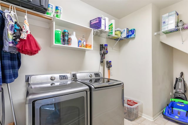 clothes washing area with light tile patterned floors and separate washer and dryer