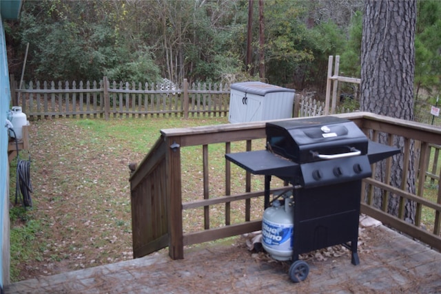 wooden deck featuring a storage unit and grilling area