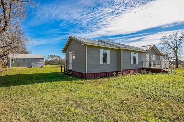 view of side of home featuring a lawn, a storage shed, and a wooden deck