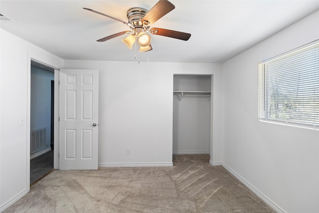 unfurnished bedroom featuring a closet, light colored carpet, and ceiling fan