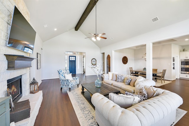 living room featuring high vaulted ceiling, dark hardwood / wood-style flooring, beamed ceiling, ceiling fan, and a fireplace