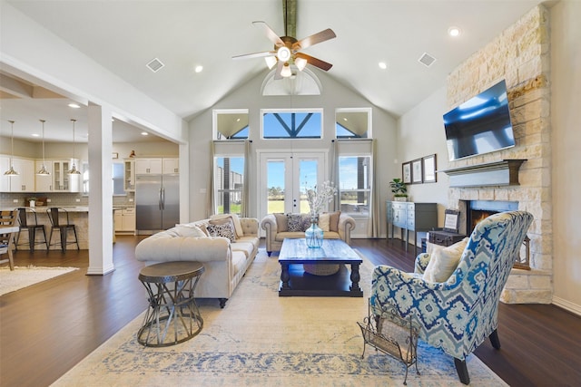 living room with high vaulted ceiling, a fireplace, dark hardwood / wood-style flooring, ceiling fan, and french doors