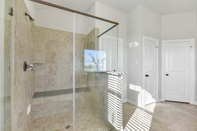 bathroom with an enclosed shower and tile patterned flooring