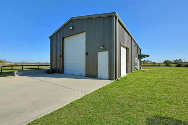 view of outdoor structure with a garage and a lawn