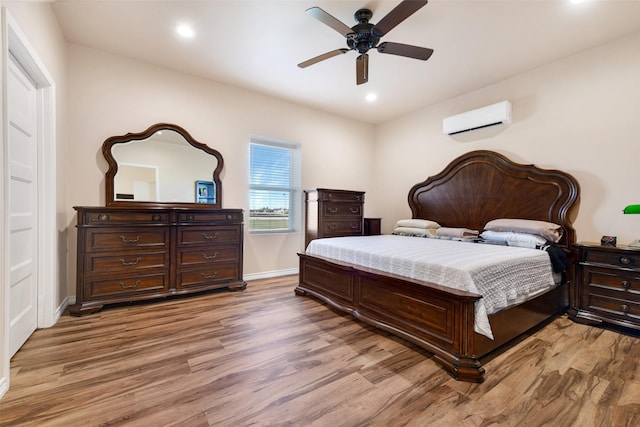 bedroom with wood-type flooring, an AC wall unit, and ceiling fan