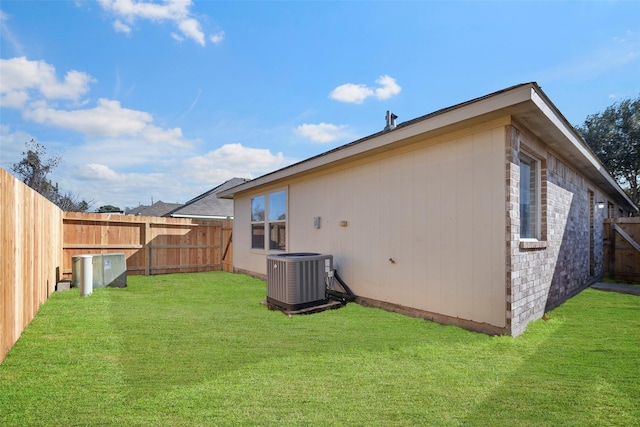 back of property featuring a yard and central AC unit