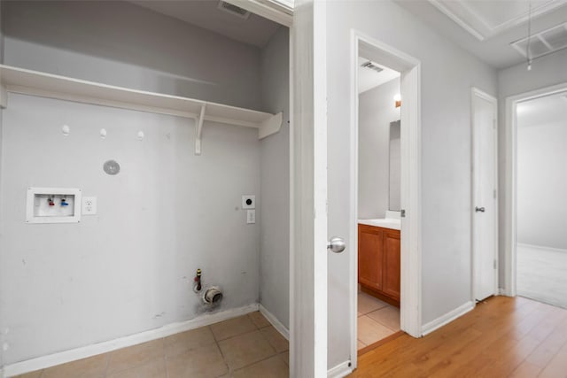 clothes washing area featuring hookup for an electric dryer, hookup for a washing machine, light tile patterned floors, and gas dryer hookup