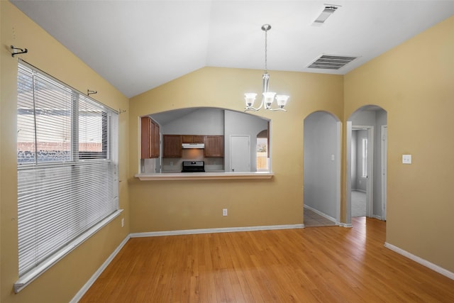 interior space featuring light hardwood / wood-style flooring, lofted ceiling, and a notable chandelier