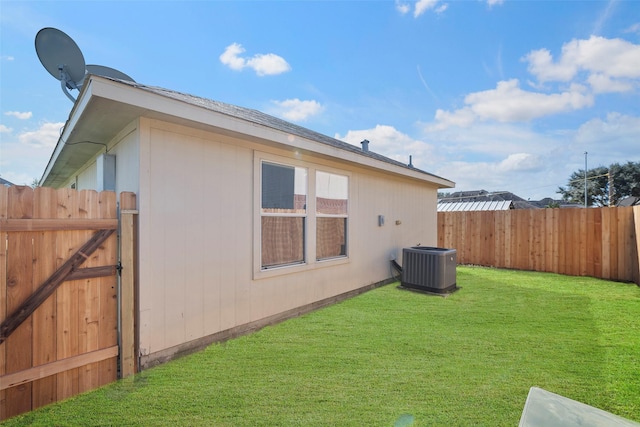 exterior space with central AC and a yard