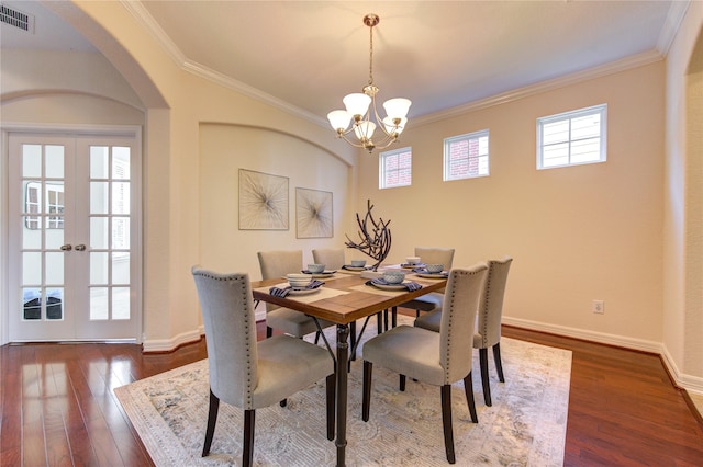 dining area featuring french doors, crown molding, a notable chandelier, dark hardwood / wood-style floors, and plenty of natural light