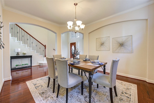 dining area with dark hardwood / wood-style floors, a notable chandelier, and ornamental molding