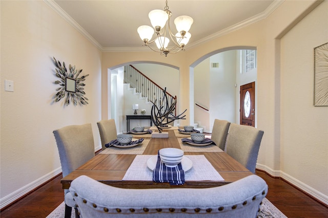 dining area featuring crown molding, dark hardwood / wood-style floors, and an inviting chandelier