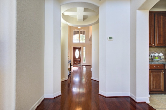 hall with hardwood / wood-style floors, beamed ceiling, and coffered ceiling