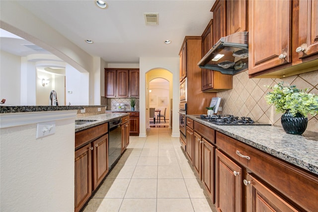 kitchen featuring dishwasher, exhaust hood, gas stovetop, light stone countertops, and light tile patterned floors