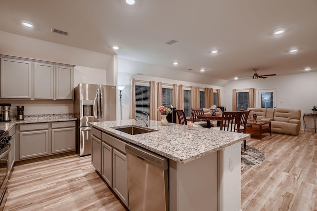 kitchen with gray cabinetry, ceiling fan, sink, a center island with sink, and appliances with stainless steel finishes