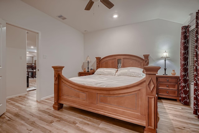 bedroom with ceiling fan, vaulted ceiling, and light wood-type flooring