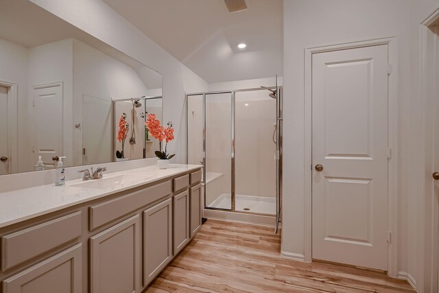 bathroom featuring hardwood / wood-style floors, vanity, and a shower with door