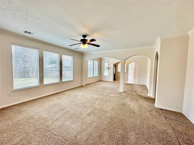 unfurnished room with arched walkways, crown molding, visible vents, carpet flooring, and baseboards