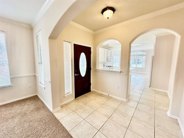 foyer entrance featuring ornamental molding, light tile patterned flooring, and baseboards