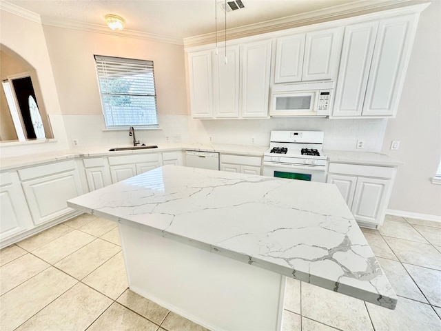 kitchen with hanging light fixtures, white appliances, white cabinets, and a sink