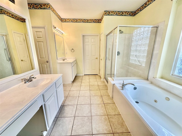 full bathroom featuring two vanities, a stall shower, a sink, a jetted tub, and tile patterned floors