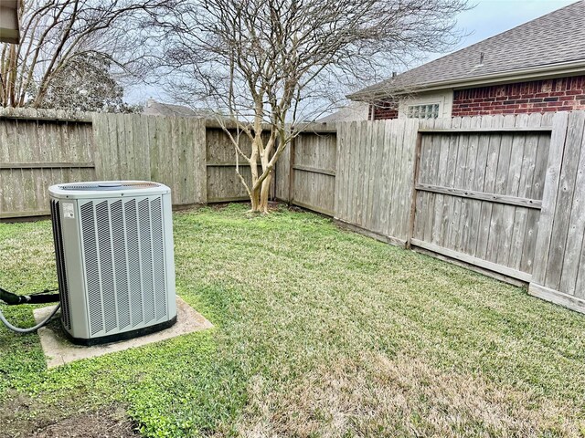 view of yard with a fenced backyard and central AC unit