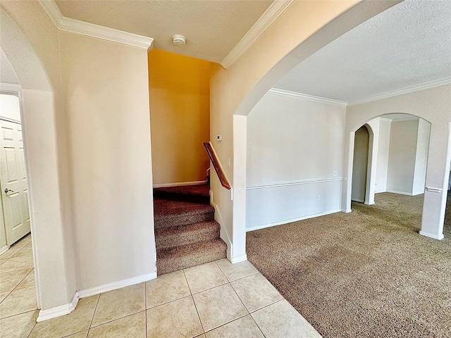 stairs featuring tile patterned flooring, carpet flooring, crown molding, and a textured ceiling