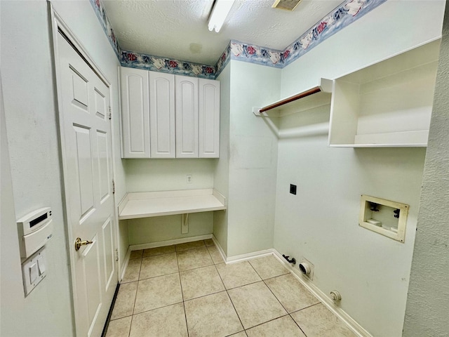 clothes washing area featuring hookup for a washing machine, cabinet space, hookup for an electric dryer, light tile patterned flooring, and gas dryer hookup