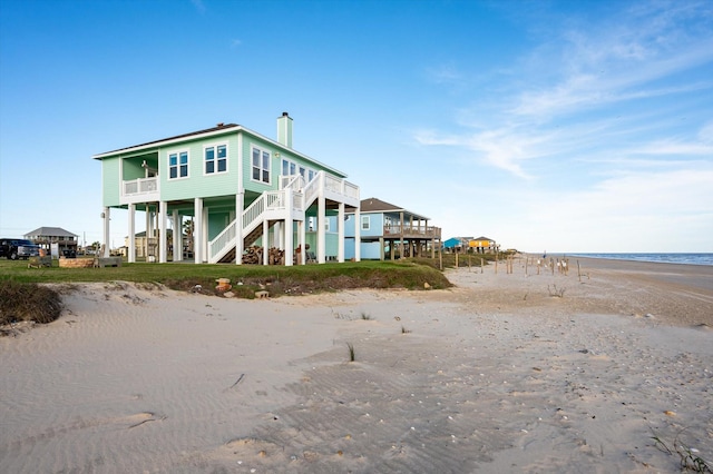 back of house featuring a beach view and a water view