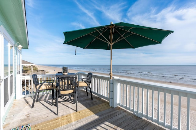 wooden deck with a beach view and a water view