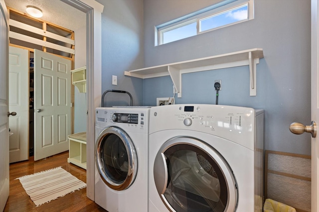 laundry area featuring washer and clothes dryer and dark wood-type flooring