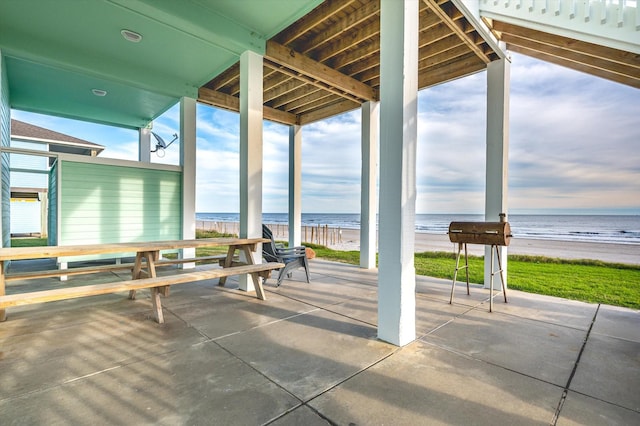 view of patio / terrace featuring a beach view and a water view