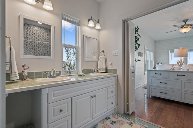 bathroom with vanity, hardwood / wood-style flooring, plenty of natural light, and ceiling fan