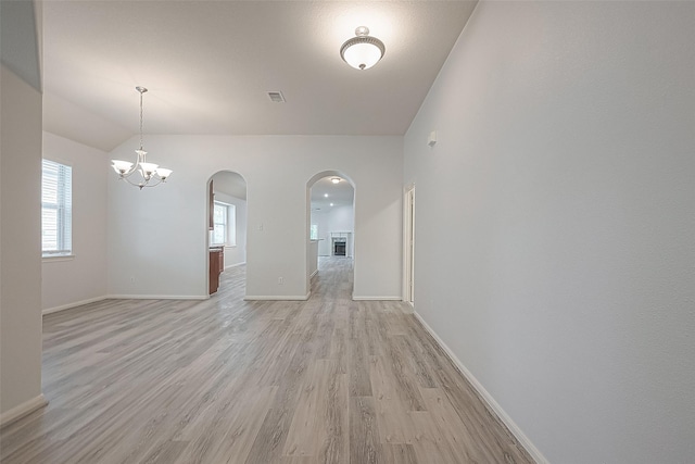 interior space featuring a chandelier, light hardwood / wood-style floors, and vaulted ceiling