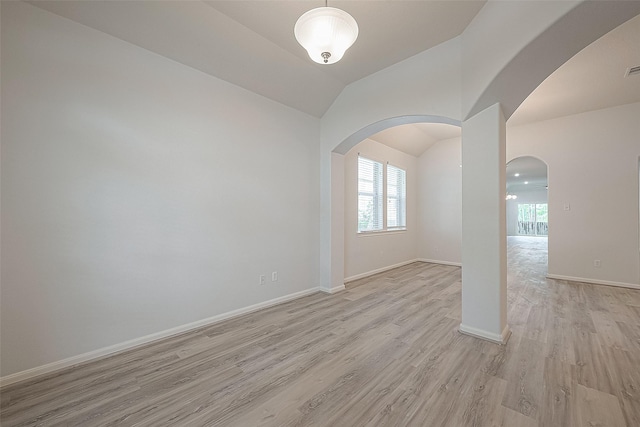 unfurnished room with light hardwood / wood-style flooring and lofted ceiling