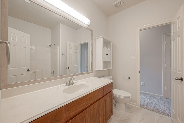 bathroom featuring toilet, a shower, and vanity