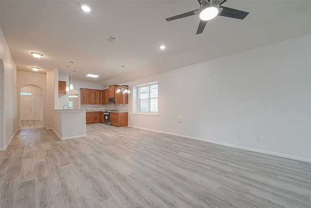 interior space featuring ceiling fan with notable chandelier and light wood-type flooring