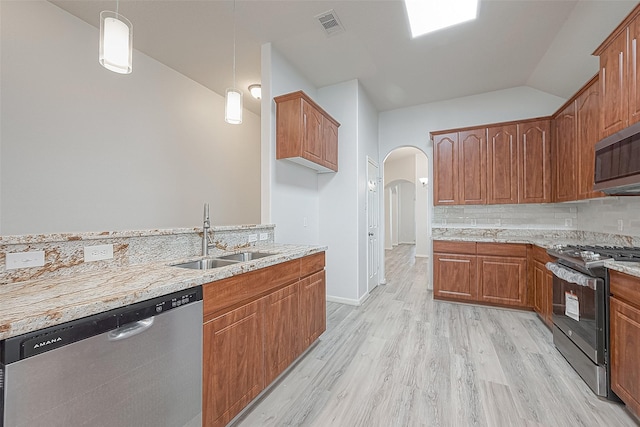 kitchen featuring light stone countertops, stainless steel appliances, hanging light fixtures, and sink