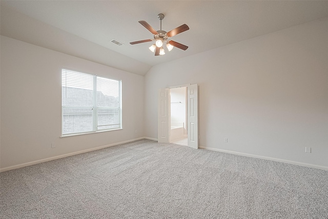 carpeted empty room featuring vaulted ceiling and ceiling fan