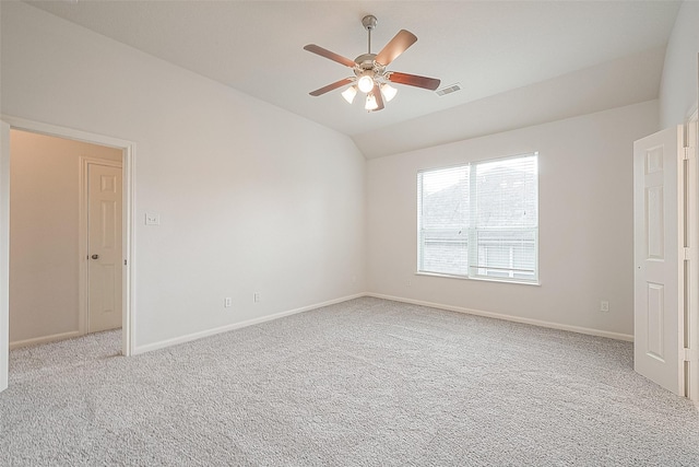 carpeted spare room with ceiling fan and vaulted ceiling