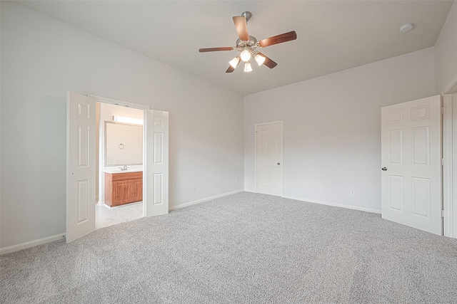 unfurnished bedroom featuring light carpet, connected bathroom, a closet, and ceiling fan