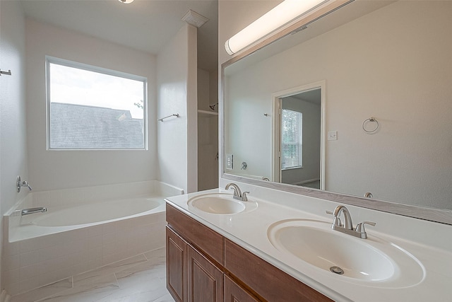 bathroom featuring vanity and tiled tub