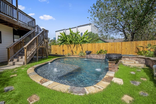 view of pool featuring pool water feature, a yard, and a wooden deck