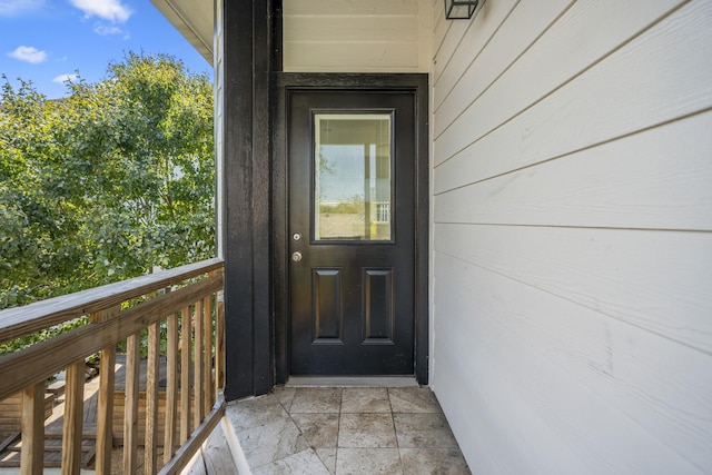 view of exterior entry featuring a balcony